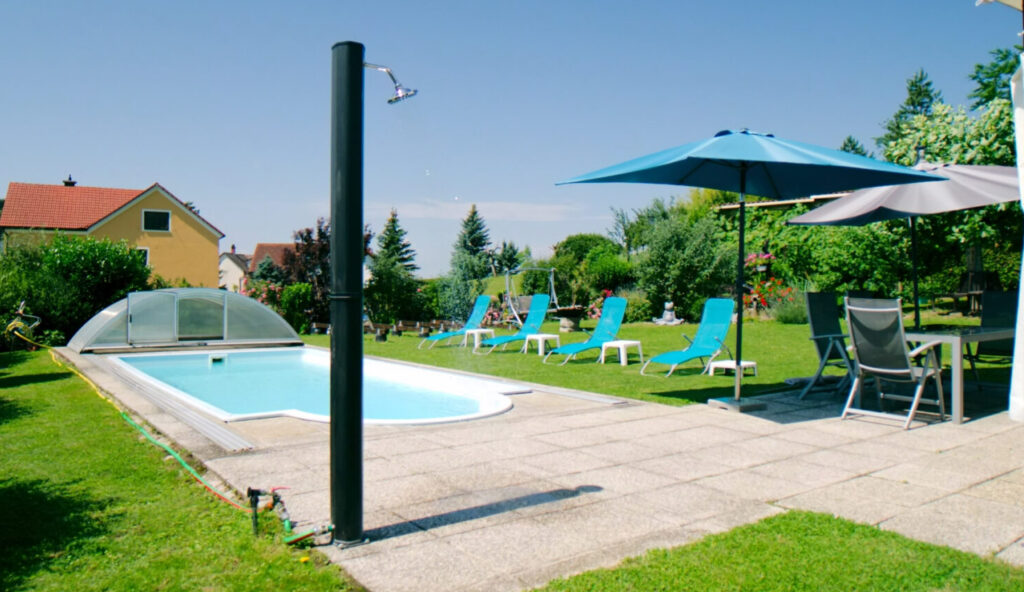 Poolbereich im Garten des Casa Ananda mit Außendusche, Sonnenliegen und überdachter Terrasse