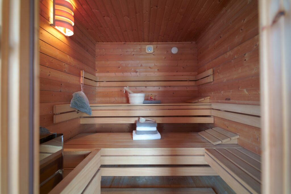 Gartensauna des Casa Ananda mit Holzbänken, Saunaofen und Aufgusskuebel